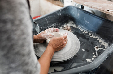 Mid section of woman making pottery