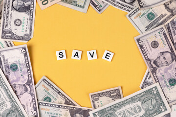 cash scattered on colorful background with the word save in the center