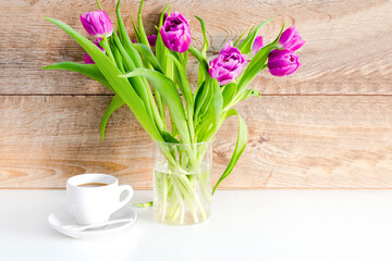 Violet purple tulips colorful bouquet in vase.Beautiful tenderness flowers.Spring floral romantic gift card,coffee, wooden background.Flower shop florist design,Womens,Valentines,Mother day concept