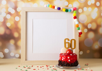 The number Sixty on the yellow cake next to the white frame mockup with copy space