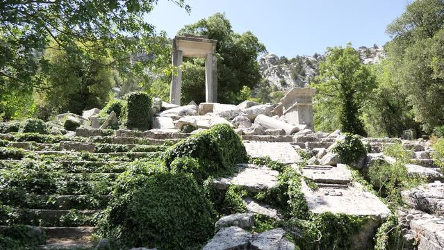 Remains of ancient Hadrian Temple of Termessos with preserved stone doorway in picturesque green park in Taurus Mountains in summer, Antalya province, Turkey