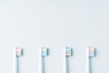 Four multi-colored nozzles from an electric toothbrush on a blue background.