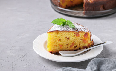 Homemade cottage cheese pie with dried apricots with a piece cut off in the foreground