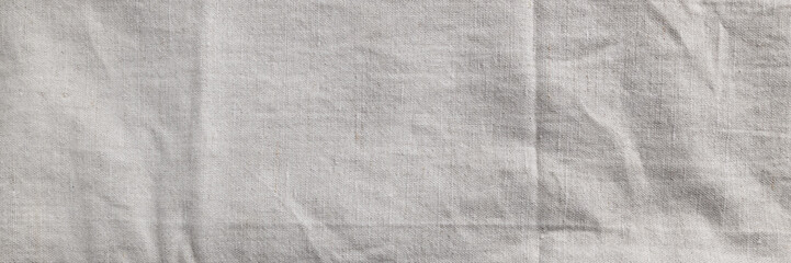 Natural linen fabric texture banner. Flaxen textile background, top view. Rough crumpled burlap panoramic web header. Wide screen wallpaper