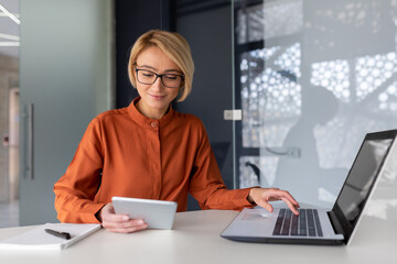 Young successful businesswoman at workplace is satisfied with results of achievement at work...