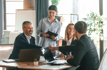 Sitting by the table. Group of business people are working in the modern office