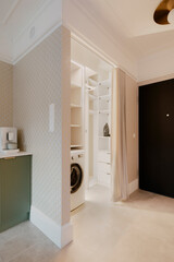 Interior design of laundry interior with washing machine, white shelf, beige patterned wallpaper, black door, gray floor and personal accessories. Home decor. Template.