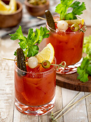 Bloody mary cocktail with garnishes on wooden table