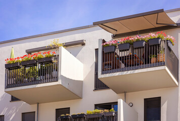 Balcony of Modern Apartment Building with Sunshade Protection Awning Marquise, Flowers in jardinieres at Terrase of Residential Building - obrazy, fototapety, plakaty