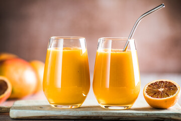 Fototapeta na wymiar Two mango lassi or kesar milk in glasses. Indian healthy ayurvedic cold drink with mango. Freshness lassi made of yogurt, water, spices, fruits and ice.