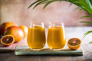 Two mango lassi or kesar milk in glasses. Indian healthy ayurvedic cold drink with mango. Freshness lassi made of yogurt, water, spices, fruits and ice.