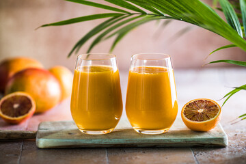Two mango lassi or kesar milk in glasses. Indian healthy ayurvedic cold drink with mango. Freshness lassi made of yogurt, water, spices, fruits and ice.