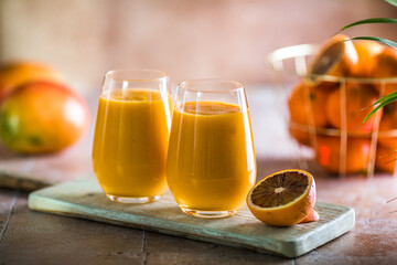 Two mango lassi or kesar milk in glasses. Indian healthy ayurvedic cold drink with mango. Freshness...
