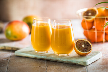 Two mango lassi or kesar milk in glasses. Indian healthy ayurvedic cold drink with mango. Freshness lassi made of yogurt, water, spices, fruits and ice.