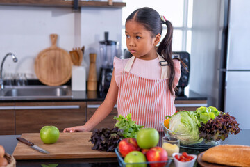 Daughter in the kitchen wait mon to learn online cooking clean food from the laptop computer