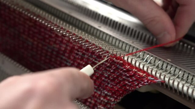 A man knits on a knitting machine. Handmade and small business