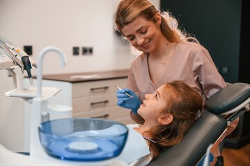 Woman is working with little girl teeth. In the stomatological cabinet