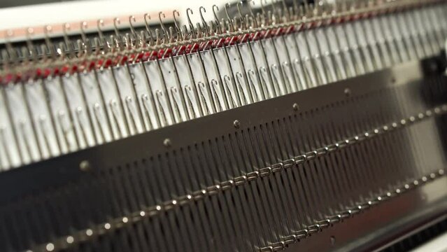 A man knits on a knitting machine. Handmade and small business