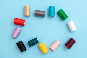 Randomly arranged colored spools of sewing threads with space in the center close-up