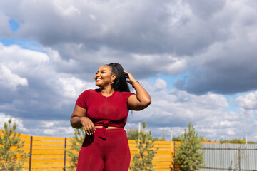 Portrait of african woman outdoors against summer sky copy space and empty space for text. Inclusion and diversity and freedom concept