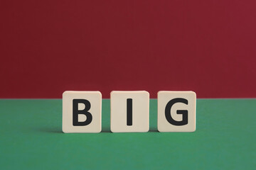 Word BIG written with leisure game tiles. Conceptual image representing a testual message communicated using letters from a board game.
