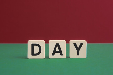 Word DAY written with leisure game tiles. Conceptual image representing a testual message communicated using letters from a board game.