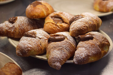 Croissants with chocolate cream on plate. Catering food service sweet food. Sweet bakery with cacao creamy filling