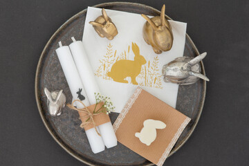 easter decoration on a plate with candles and bunnies, copy space