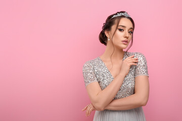 Beautiful young woman wearing luxurious tiara on pink background, space for text