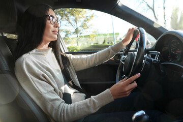 Beautiful young woman on driver's seat in modern car