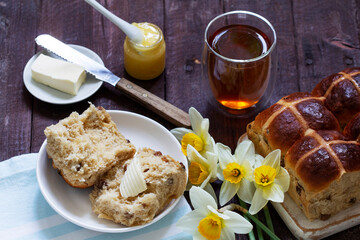 Cross buns served with butter, honey and tea. Easter breakfast.