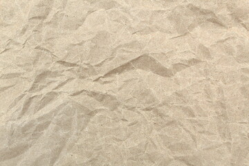 Abstract brown crumpled paper texture with folds.
