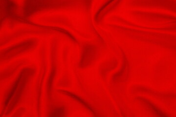 Fototapeta na wymiar The satin red fabric lays beautifully draped.