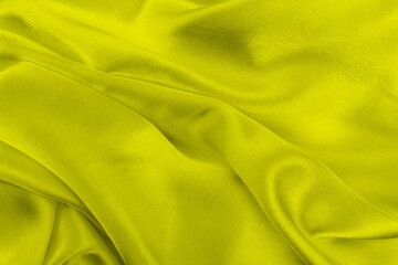 Satin beautiful yellow silk fabric lies with drapery.