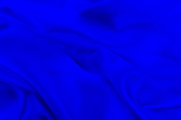 Satin beautiful blue silk fabric lies with drapery.	