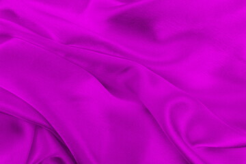 Satin beautiful silk fabric in lilac color lies with drapery.	