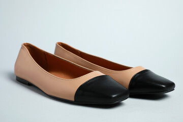 Pair of new stylish square toe ballet flats on light grey background