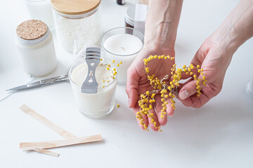 closeup of woman hands decorating handmade candle