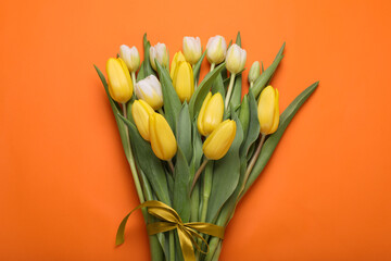 Bouquet of beautiful yellow tulips on orange background, top view