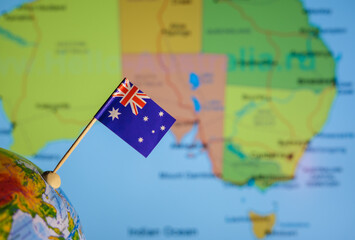 The flag of Australia on the background of the map of Australia is out of focus.