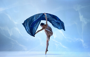 Adorable dancer wearing beige bodysuit dancing with fabric silk over blue background © Lustre Art Group 