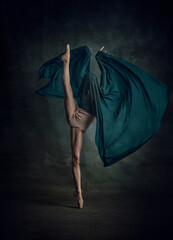 Young and incredibly beautiful ballerina standing in twine and holding silk fabric over dark green background © Lustre Art Group 