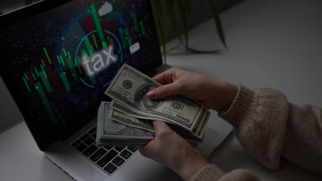 businesswoman sitting in her office and holding money near laptop