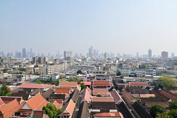 Obraz premium BANGKOK, THAILAND - April 12, 2023 : Landscape View of Bangkok City and Thai Buddhist Temple with Blue sky with white cloud. Clear day and good weather in the morning.
