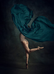 Portrait of young ballerina dancing with fabric over dark background. Back view