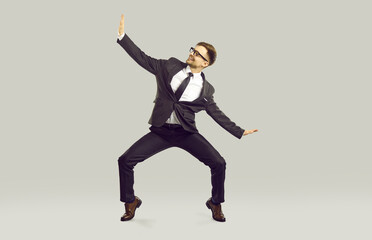 Work day is over let's go home. Happy office worker having fun because weekend starts now. Full body length cheerful joyful funny excited business man in suit dancing isolated on light gray background