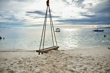 Dreamlike idyllic beach of Siquijor in the Philippines with a wooden swing in focus.