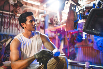 Fototapeta na wymiar Portrait of a confident Asian male mechanic holding wrench at garage, Auto mechanic standing against a car in a repair garage for using in business of car, expertise mechanic working in automobile