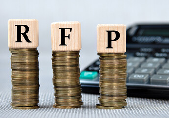 RFP - acronym on wooden cubes on the background of coins and calculator