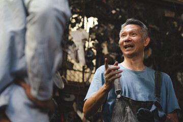 Concentrated technician and experienced car engine repair specialist, Confident Asian man auto mechanic working in automobile repair garage, industrial business of maintenance workshop service